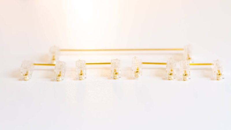 Clear Durock V2 stabilizers with gold wires for custom mechanical keyboards.